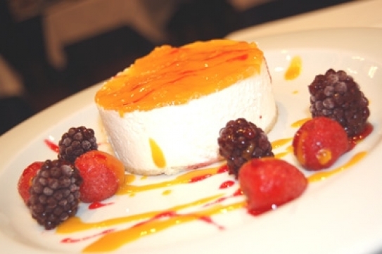 Flan de nata con almíbar de naranja y frutos rojos