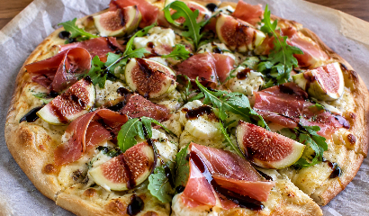 Pizza de higos, queso de cabra, jamón y rúcula